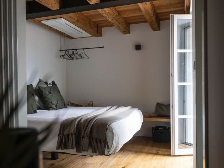 Schlafzimmer im Design-Apartment mit Holzbalkendecke